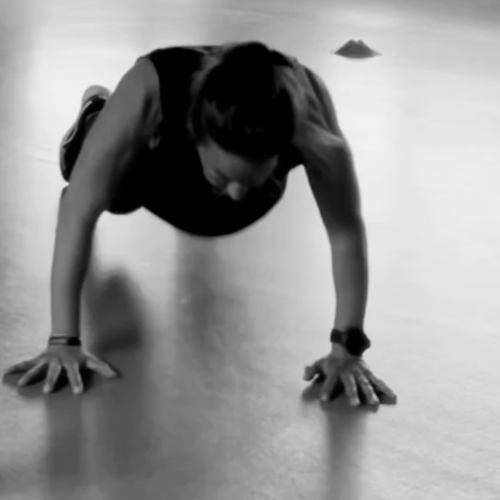 Jo Angele macht ein Burpee: sie stützt sich auf den Armen auf und ist in einer Plank-Position. 